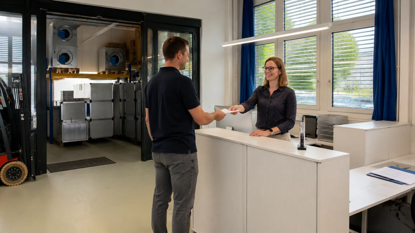 Fachbetrieb erhält am Empfang von Lüftungsprofis die Unterlagen zum Gerät.